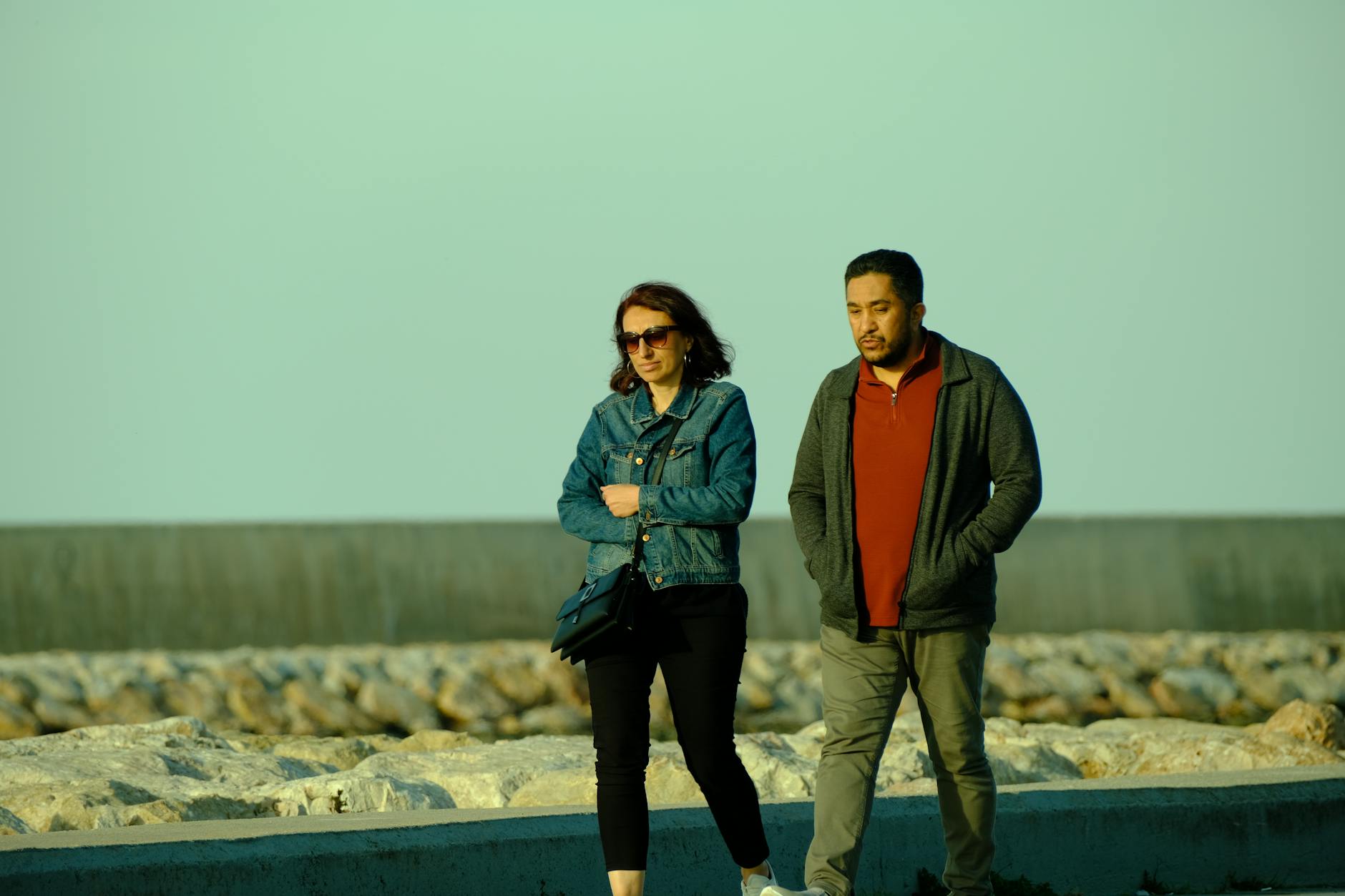 Para spaceruje po kamienistym brzegu morza w Gdyni Orłowie