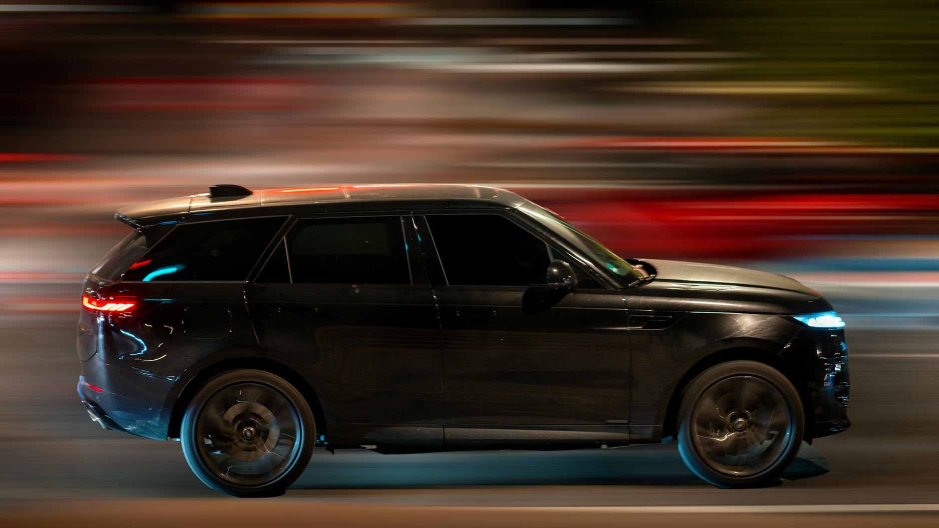 Czarny SUV Subaru jedzie nocą po oświetlonych ulicach miasta