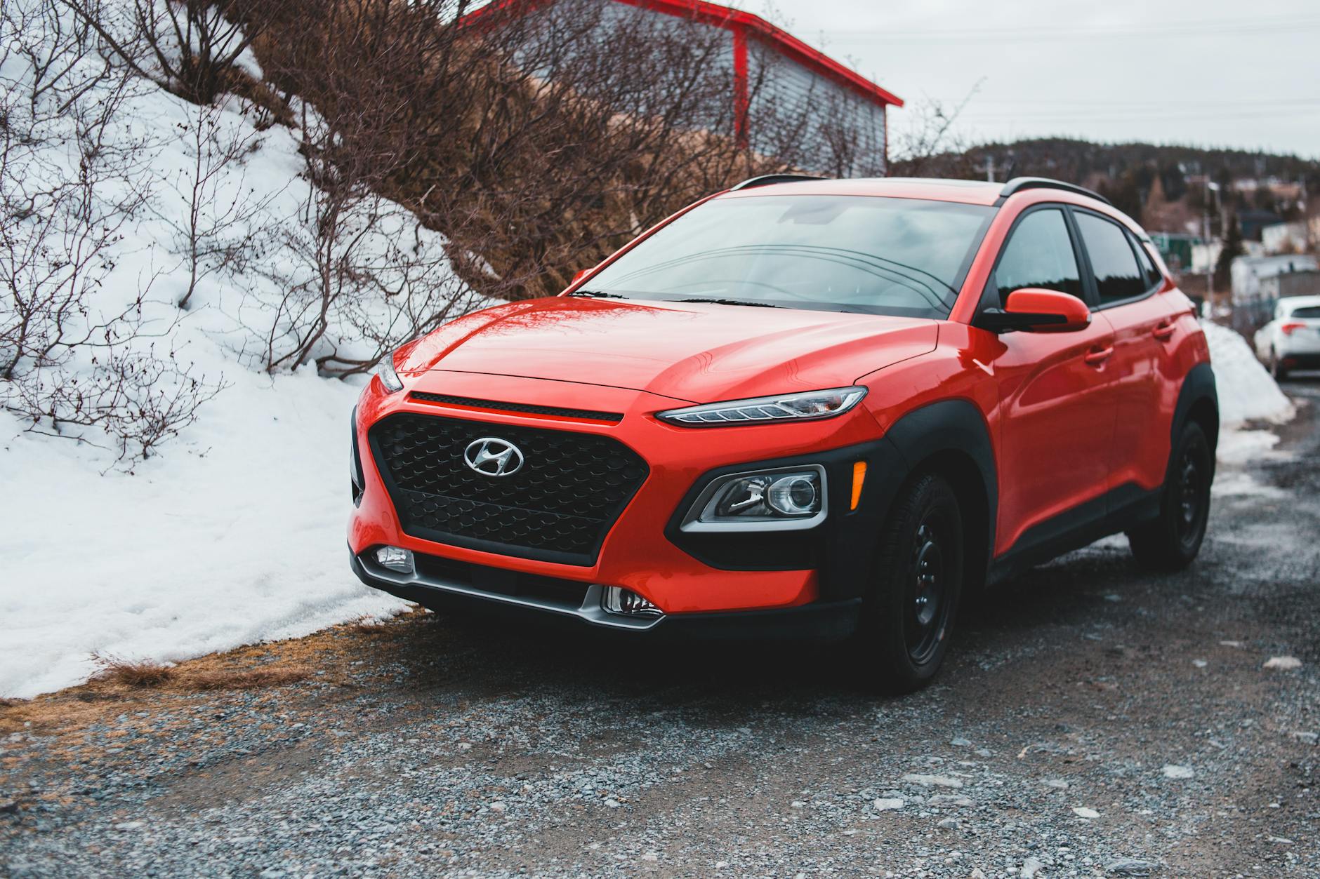 Czerwony SUV Hyundai zaparkowany na śniegu na tle zimowego krajobrazu