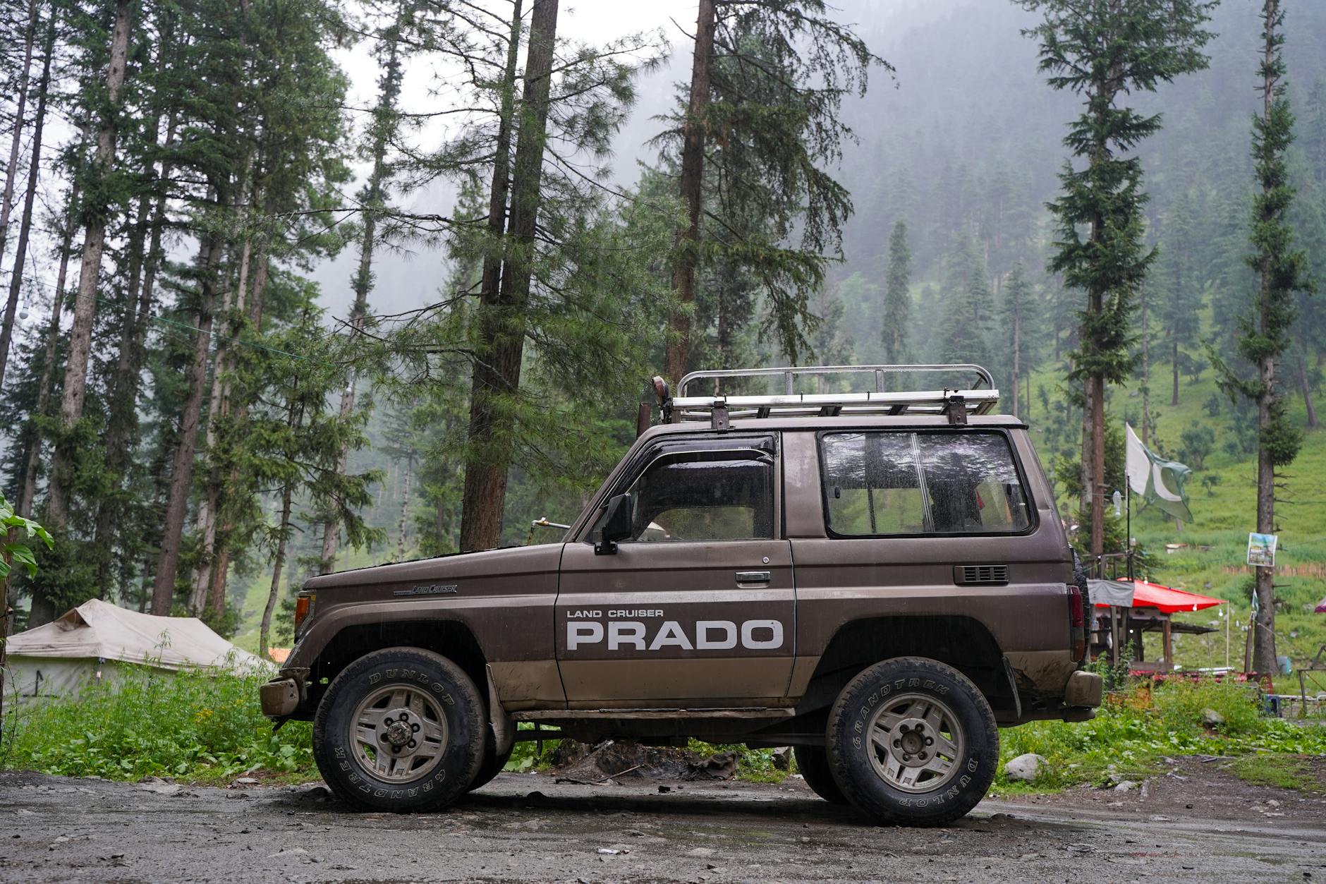 Toyota Land Cruiser Prado zaparkowana w zielonym lesie podczas offroadu