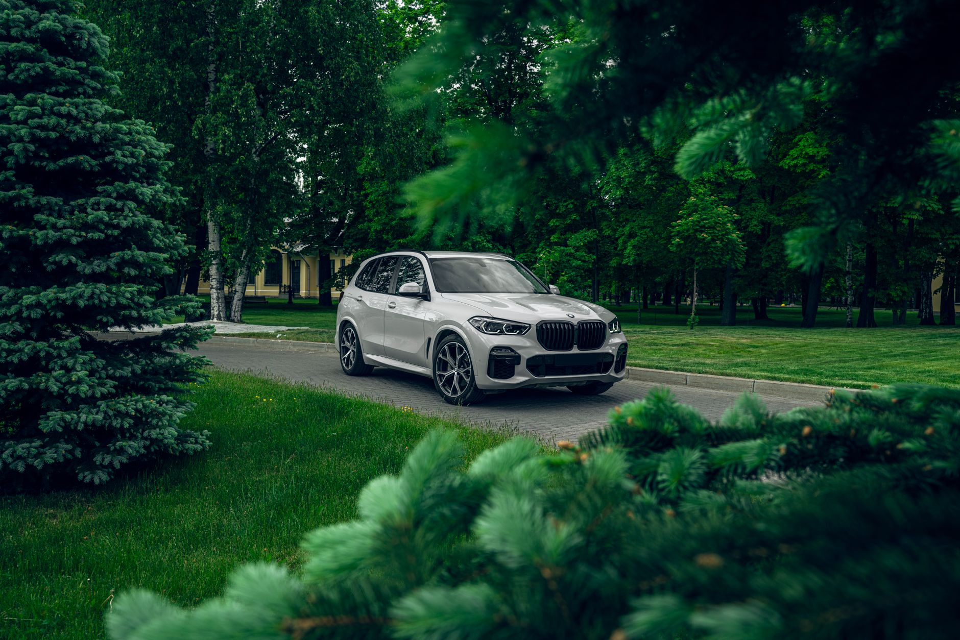 Maserati Levante jako rodzinne auto premium: praktyczne zalety i ukryte wady w codziennym użytkowaniu Białe Maserati Levante zaparkowane w zielonym parku