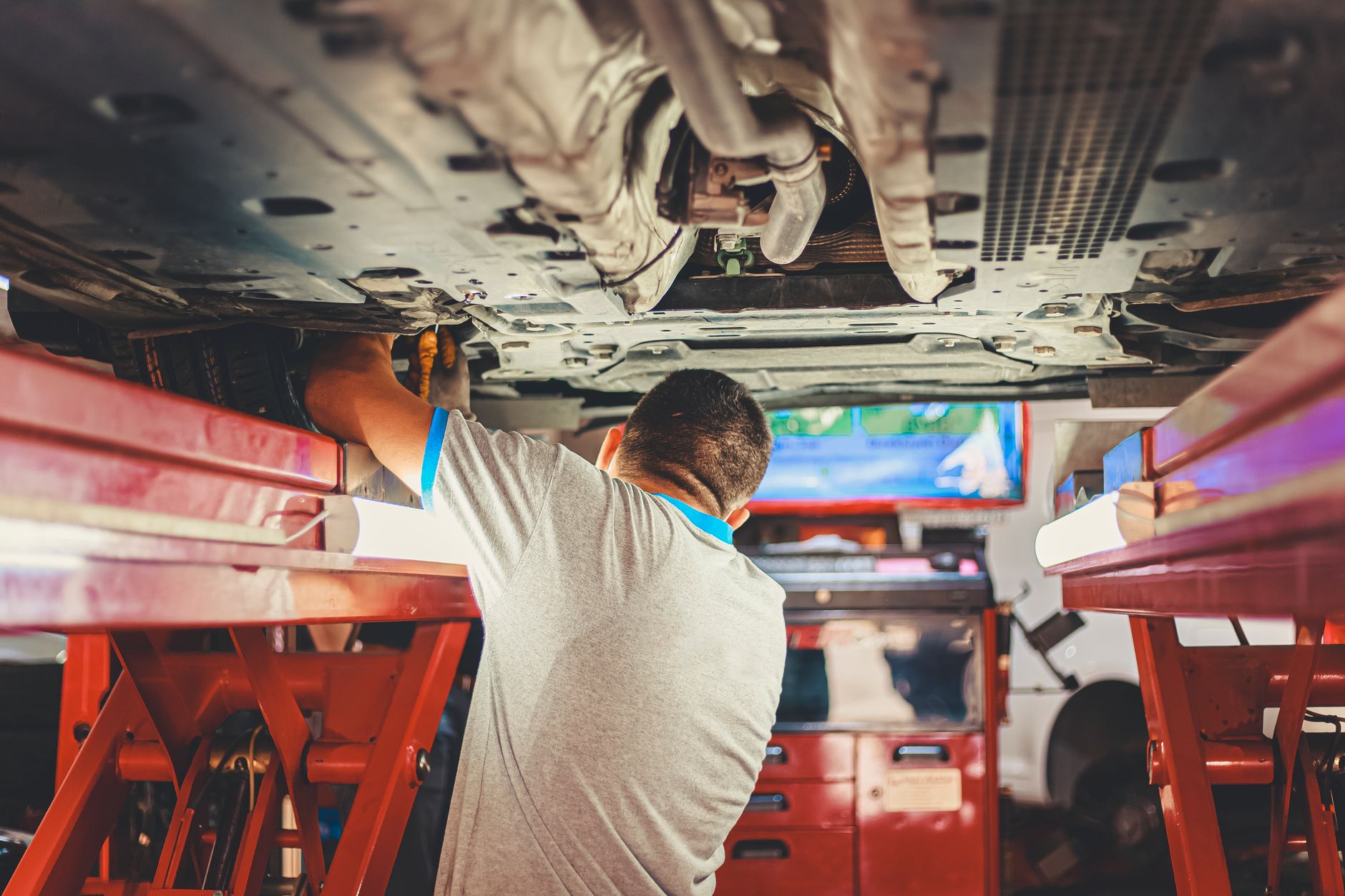 Mechanik sprawdza podwozie podniesionego BYD w warsztacie samochodowym