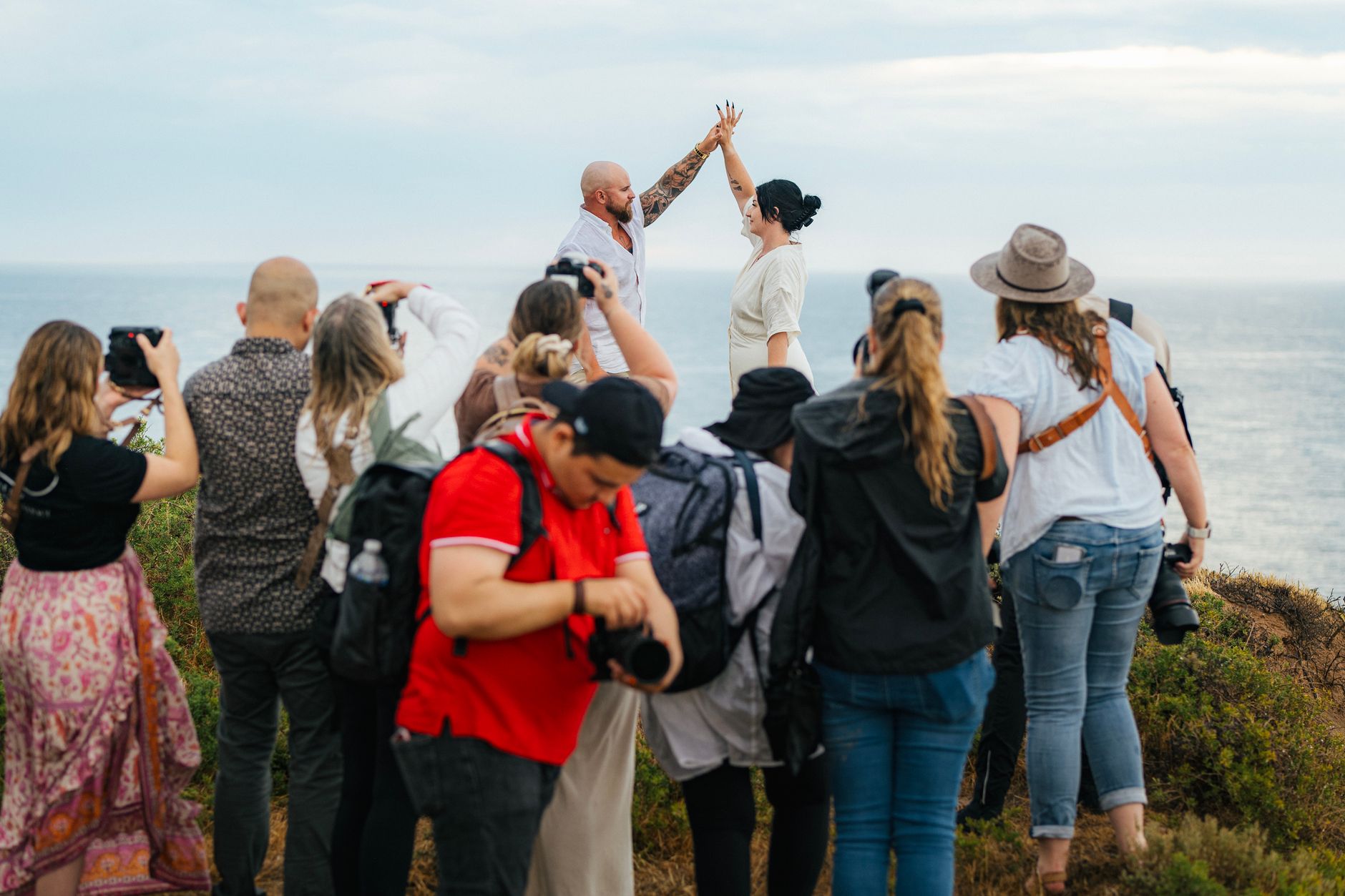 Para młoda nad morzem w otoczeniu fotografów podczas pleneru ślubnego Para młoda nad morzem w otoczeniu fotografów podczas pleneru ślubnego