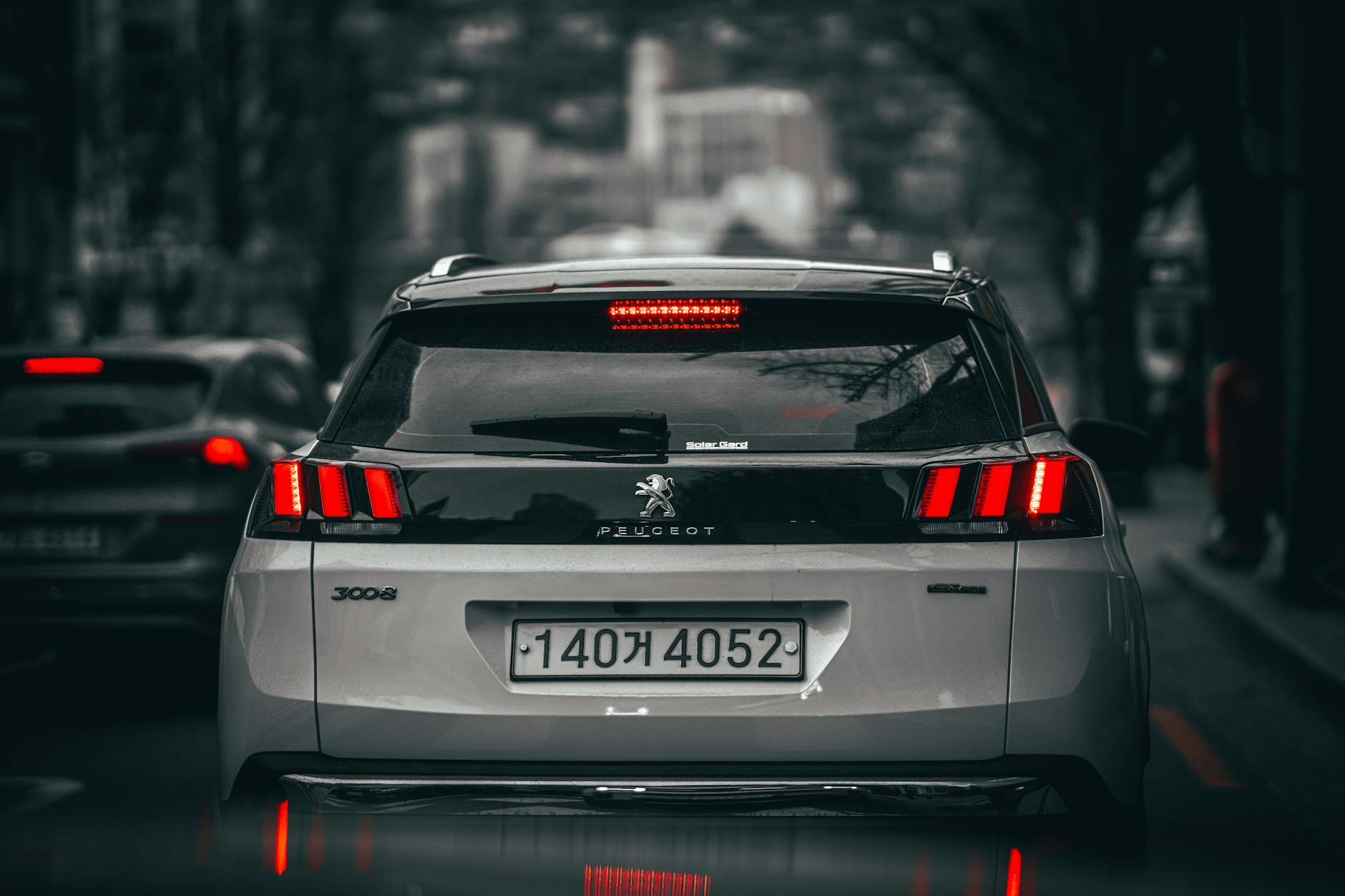 Tył nowoczesnego SUV-a Jeep Renegade jadącego po ruchliwej ulicy miasta