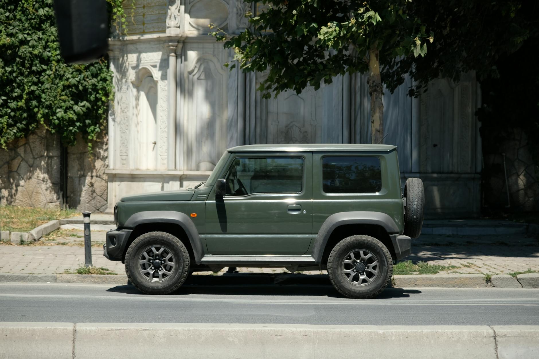 Zielony terenowy SUV zaparkowany na słonecznej miejskiej ulicy