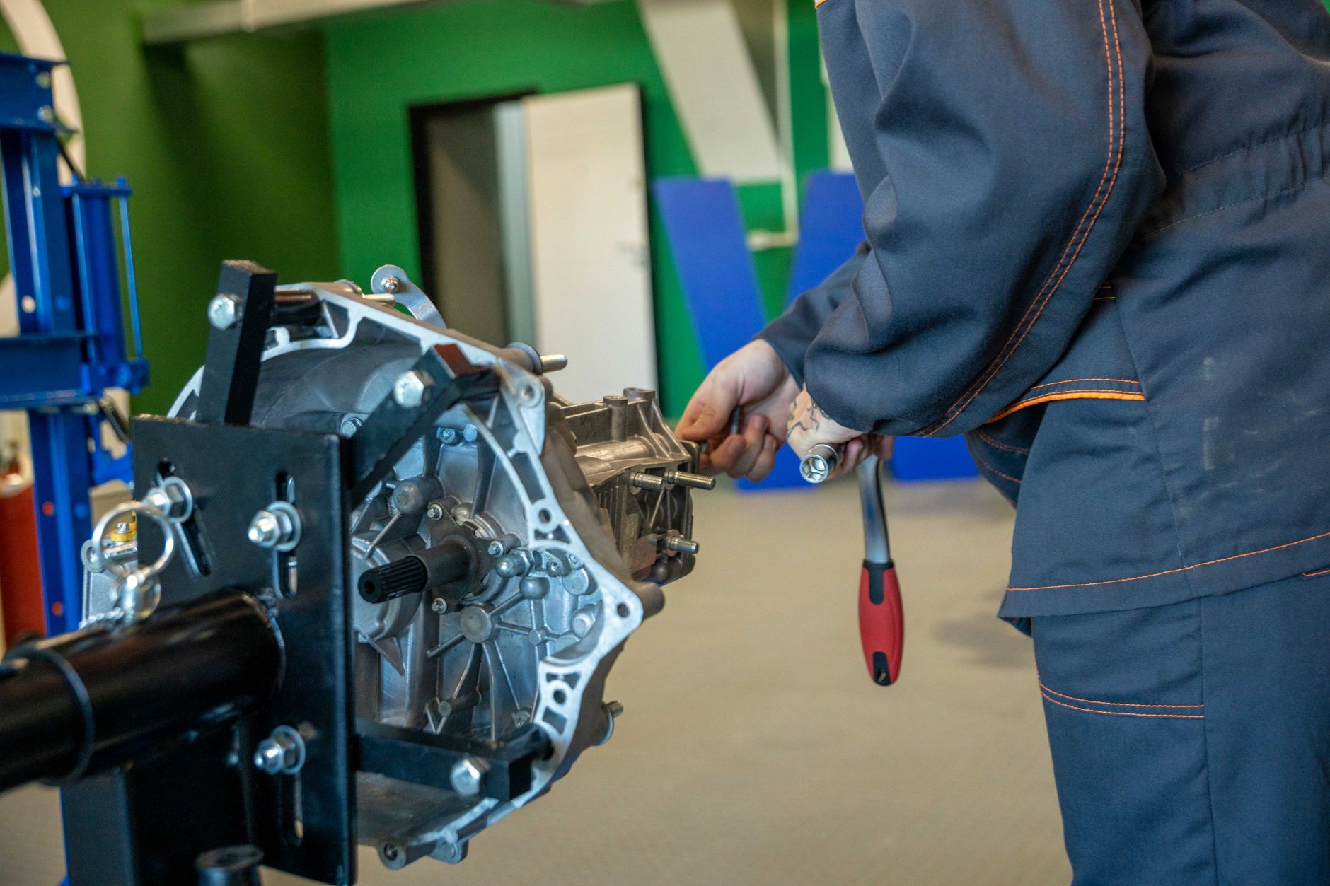 Mechanik naprawia skrzynię biegów w warsztacie Jeepa Mechanik naprawia skrzynię biegów w warsztacie Jeepa